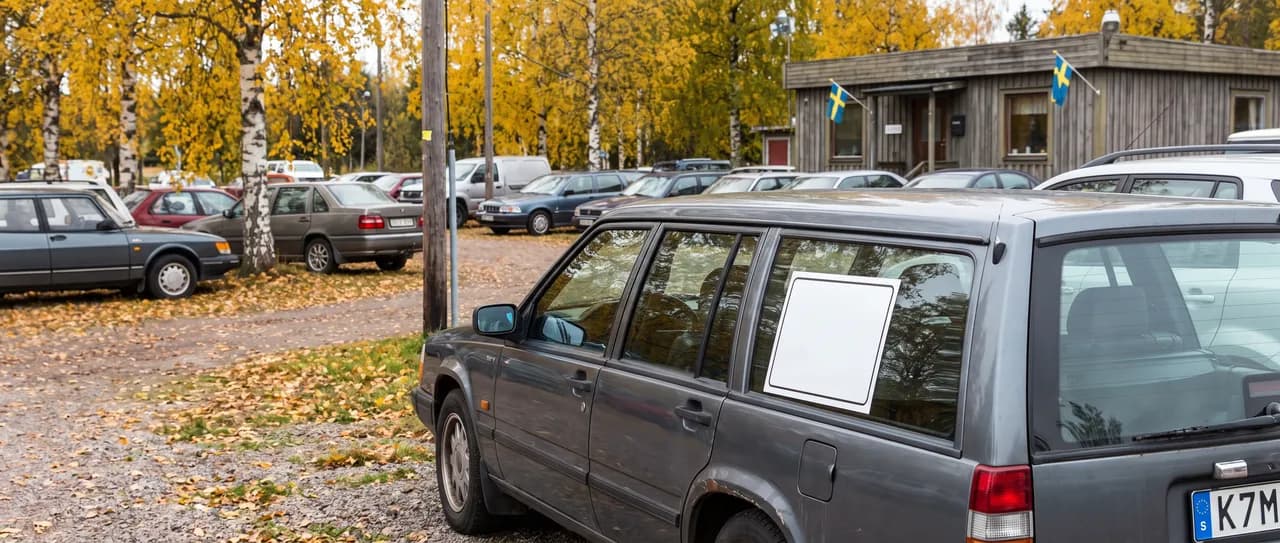 Bildmontage: en begagnad kombi med prisskylt i sidorutan på en bilhandlares uppställningsplats en klar höstdag
