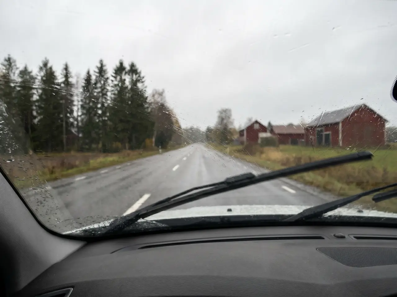 Bildmontage: suddig sikt genom obehandlad vindruta i regn