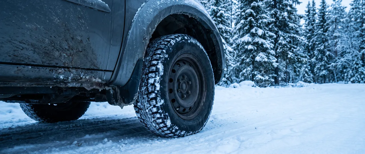 Bildmontage: SUV-hjul med vinterdäck på en snöig skogsväg i norra Sverige